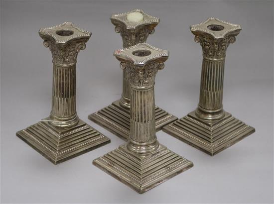 A set of four plated candlesticks height 15cm